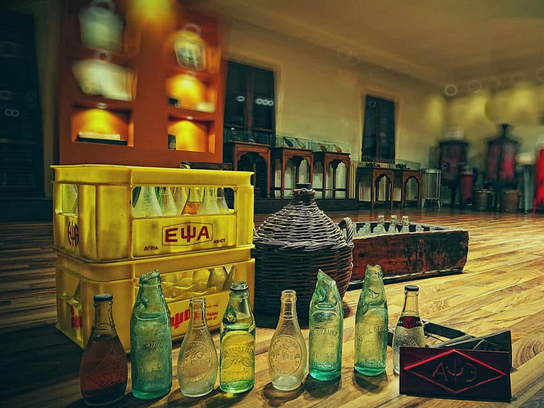 collection of old small bottles of soft drinks on the floor of 'Epsa' museum