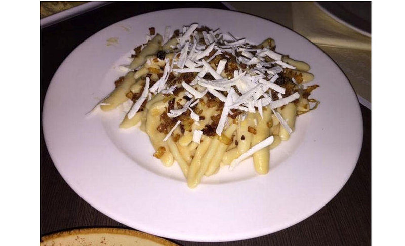 Close-up of Greek ‘Macarounes’ long pasta, like thin Italian tagliatelle served with minced meat and grated cheese on top