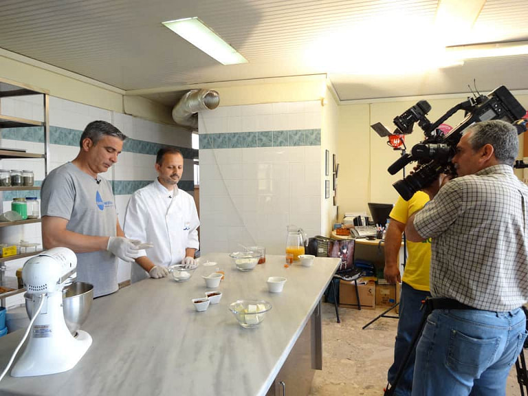 two men cooking and another taking video with camera at 'Athanasopoulos Farm'