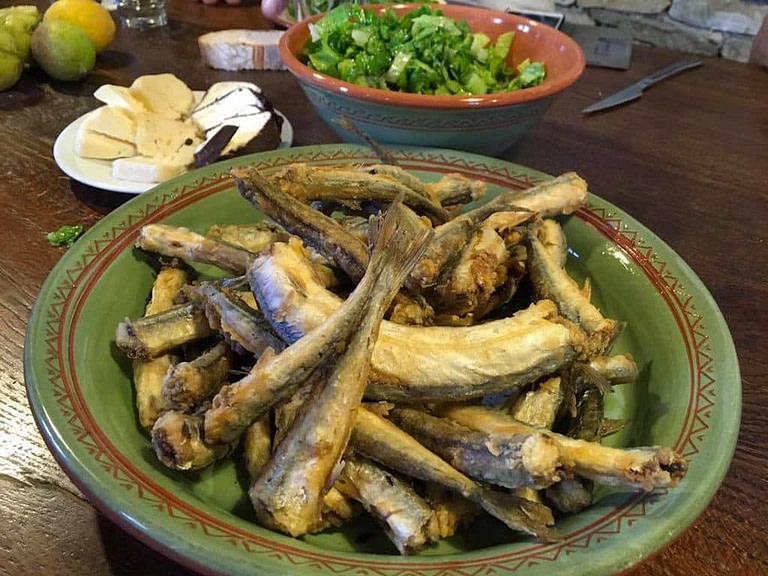 close-up of plates with frying anchovies and salad at 'Narlis Farm'