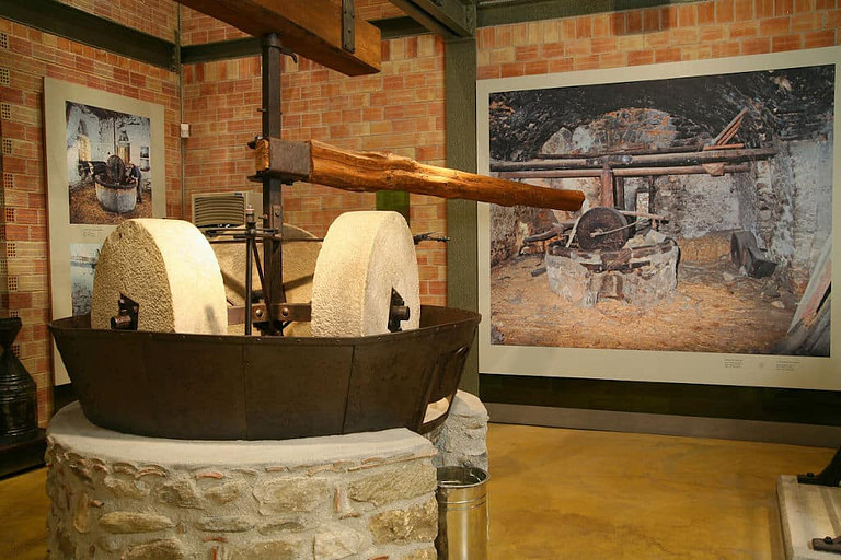 old stone olive press at 'Olive and Olive Oil Museum, Sparta' with posters with the same