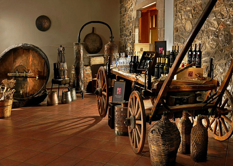 old cart with wine bottles and various jugs and copper saucepans at 'Muses Estate' on the ground
