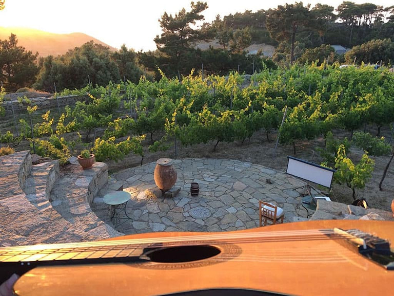 a guitar in the background of the outdoor stone amphitheater and the vineyards at Afianes' winery