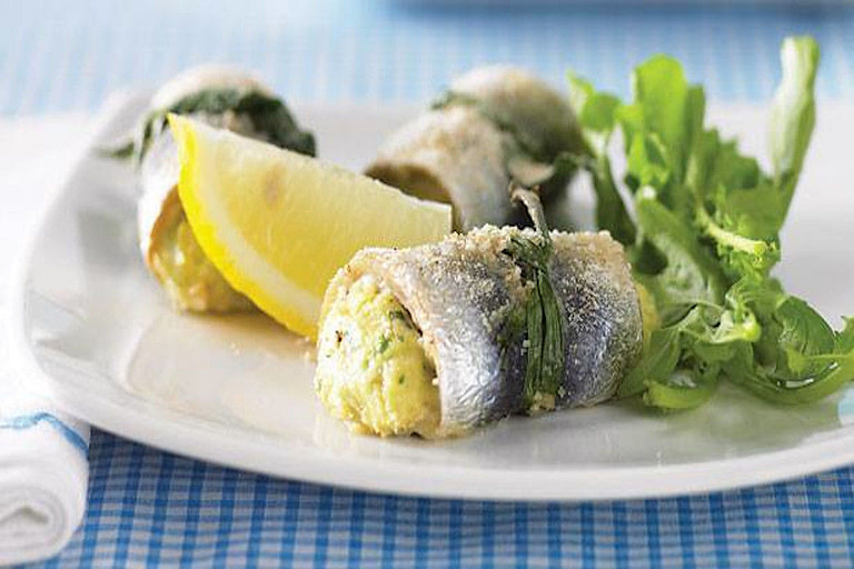 stuffed sardine fillets with lemon slice and green vegetable on a plate at 'Stella Mare Fisheries'
