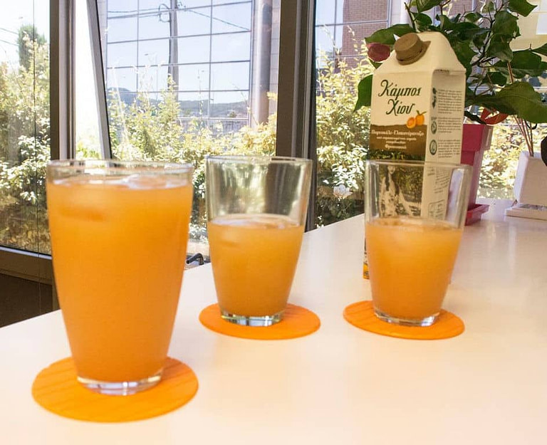 glasses with orange juice on the table at Chios Fruits's premises