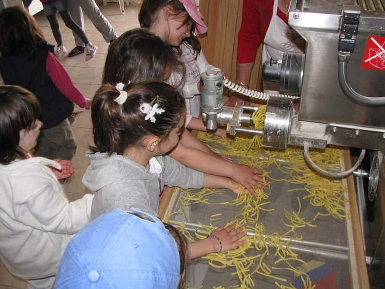 children working at hilopites pasta machine at Thracian Pasta workshop