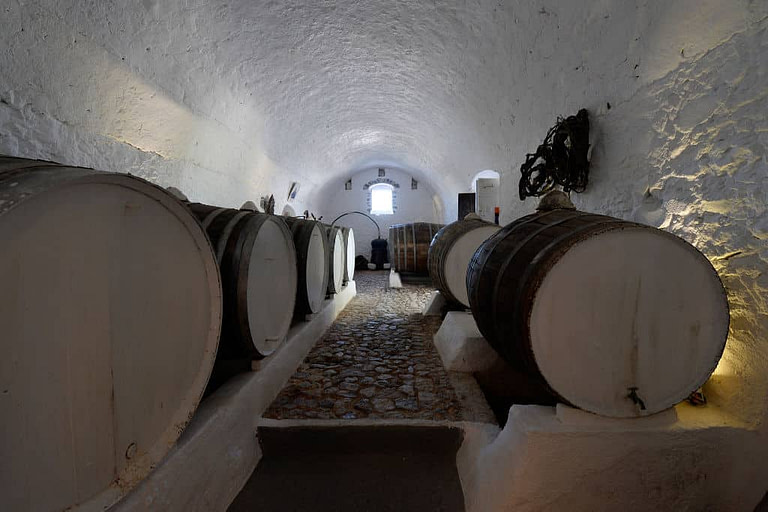 wooden barrels in stone cellar at Canava Roussos Winery