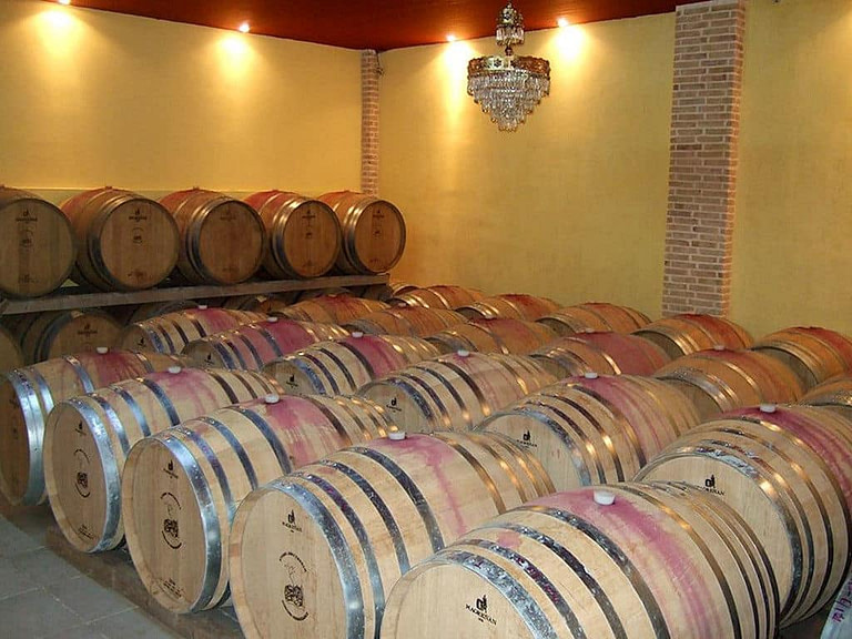 wine wood barrels on the ground and another row on top of each other at 'Domaine Anagennisi' cellar