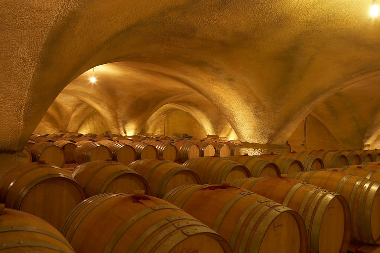 illuminated 'Domaine Claudia Papayianni' cellar with ceiling with arcades and barrels on the floor