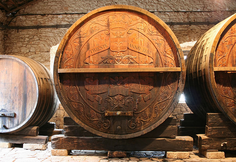 engraved personalized wooden wine barrels sign with the 'Achaia Clauss winery' logo into the cellar