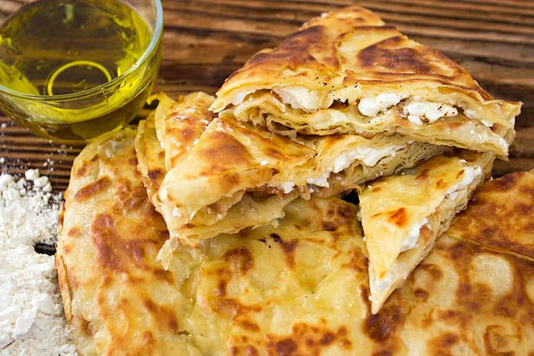 pieces of 'perek' pie and a glass of oil at 'Agios Antonios Women’s Agri Cooperative'
