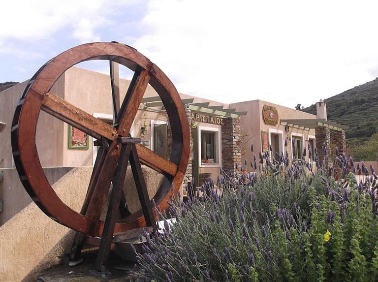 old wooden watermill in the background of 'Aristaios' store