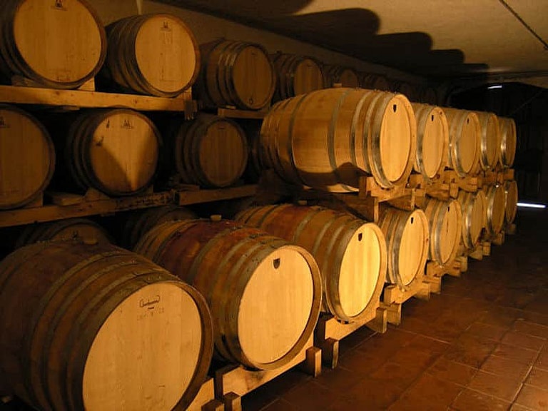 wine wood barrels on top of each other in a row at 'Lafkiotis Winery' cellar